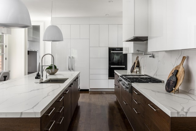 kitchen with black double oven, tasteful backsplash, dark hardwood / wood-style flooring, white cabinetry, and stainless steel gas cooktop