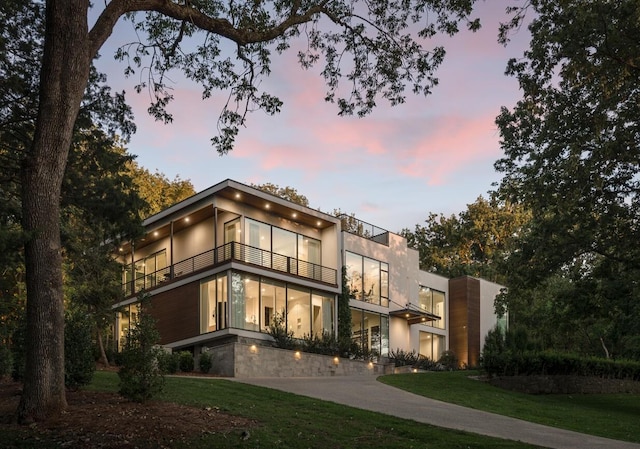 contemporary house with a lawn and a balcony