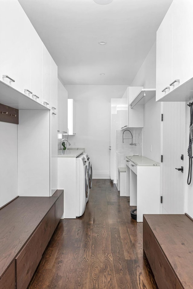 washroom with dark hardwood / wood-style floors, cabinets, sink, and washing machine and clothes dryer