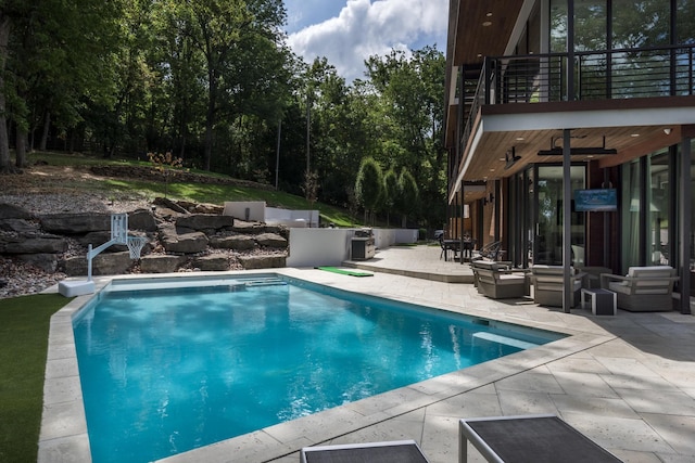 view of swimming pool with ceiling fan and a patio