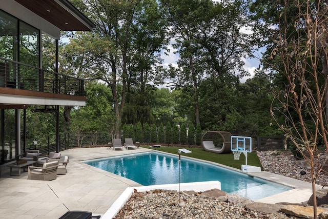 view of pool with a diving board and a patio