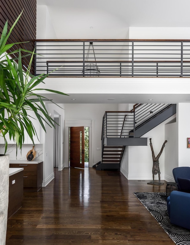 entryway with dark hardwood / wood-style flooring and a towering ceiling