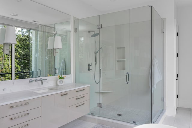 bathroom featuring tile patterned flooring, vanity, a shower with door, and plenty of natural light