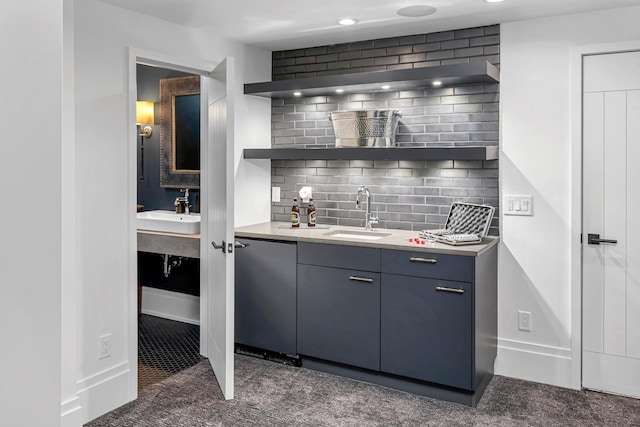 interior space featuring decorative backsplash, stainless steel dishwasher, and sink