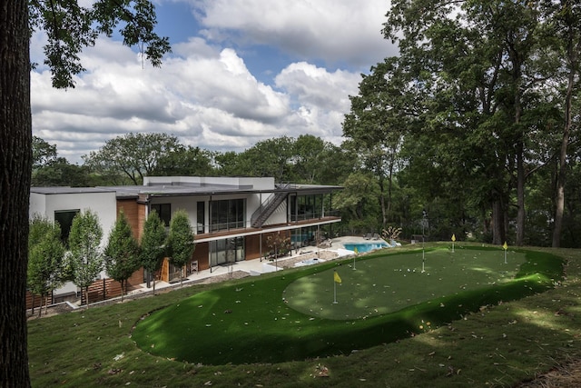 rear view of house featuring a yard, a balcony, and a patio area