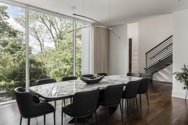 dining space featuring dark hardwood / wood-style flooring and a wall of windows