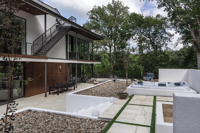 view of patio / terrace featuring a balcony and a hot tub