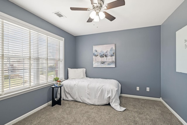 carpeted bedroom featuring baseboards, visible vents, and ceiling fan