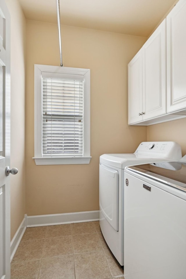 laundry room with light tile patterned flooring, cabinet space, baseboards, and separate washer and dryer