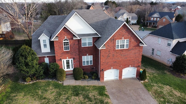 traditional-style house featuring concrete driveway, roof with shingles, crawl space, an attached garage, and brick siding