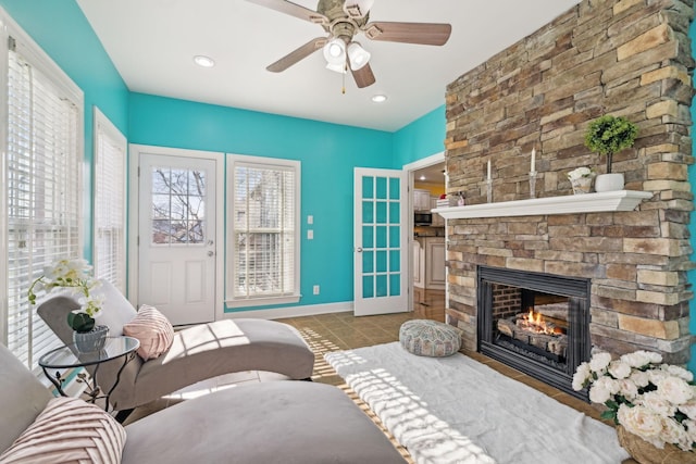 tiled living room featuring ceiling fan, recessed lighting, a fireplace, and baseboards