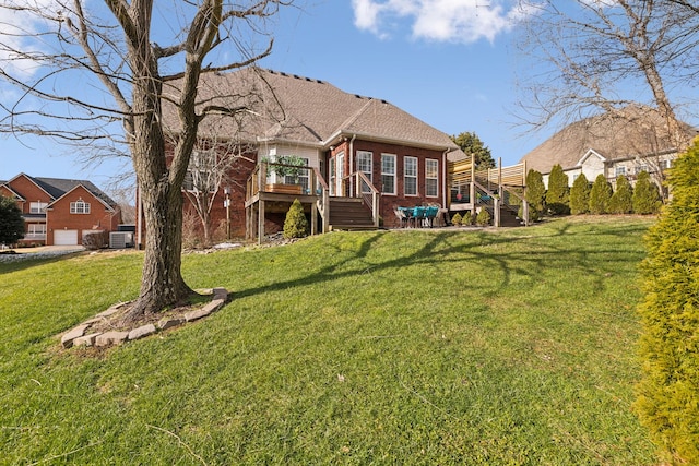 back of house with a lawn, stairway, a wooden deck, central air condition unit, and brick siding