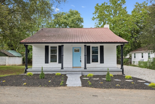 bungalow-style home with covered porch and a storage unit