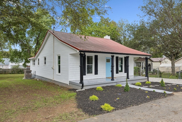 view of front of home featuring a front yard, a porch, and cooling unit