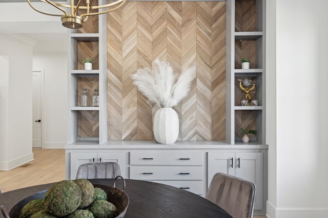 dining space featuring built in features and a notable chandelier