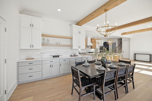 kitchen with white cabinetry, beam ceiling, custom exhaust hood, and decorative light fixtures