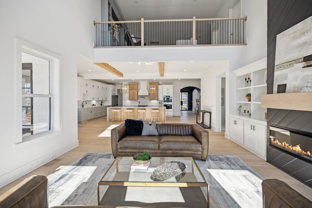 living room featuring a towering ceiling and light hardwood / wood-style flooring