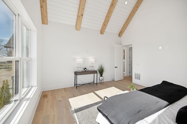 bedroom with vaulted ceiling with beams, light hardwood / wood-style flooring, and wooden ceiling