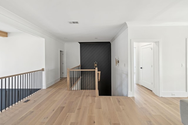 corridor featuring ornamental molding and light wood-type flooring