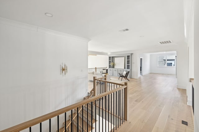 hallway featuring crown molding and light wood-type flooring