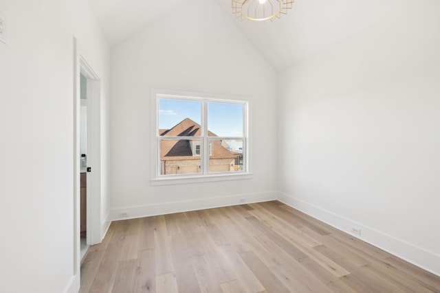 empty room with high vaulted ceiling and light wood-type flooring