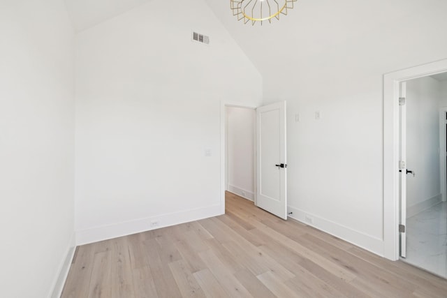 unfurnished room featuring high vaulted ceiling and light wood-type flooring