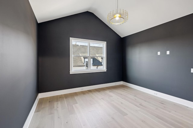 empty room featuring vaulted ceiling and light wood-type flooring