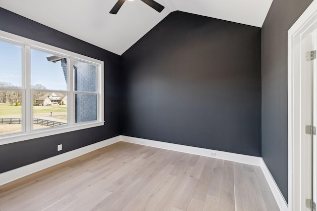 empty room with ceiling fan, lofted ceiling, and light hardwood / wood-style floors