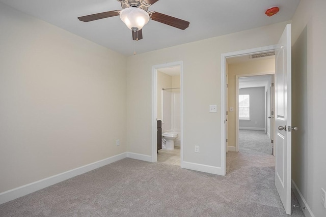 unfurnished bedroom with ensuite bathroom, ceiling fan, and light colored carpet