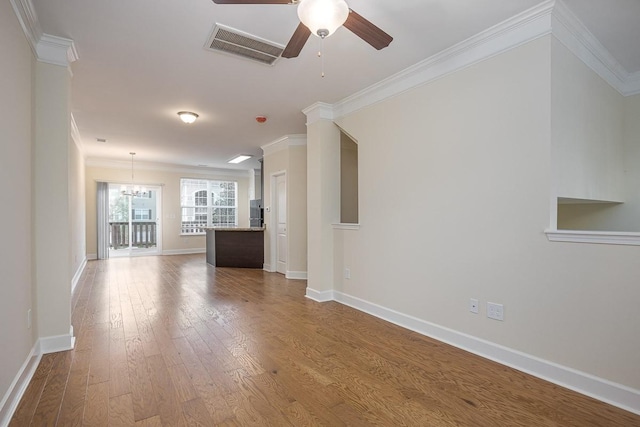 unfurnished living room featuring crown molding, hardwood / wood-style floors, and ceiling fan with notable chandelier