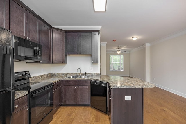 kitchen with kitchen peninsula, crown molding, sink, black appliances, and light hardwood / wood-style floors