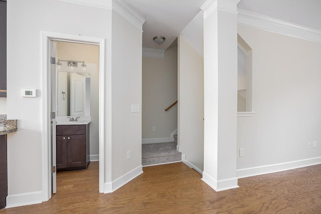 hall with hardwood / wood-style floors, crown molding, and sink