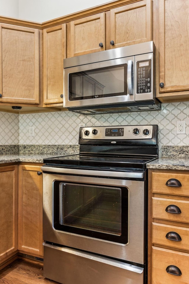 2016 Shamrock Dr, Spring Hill, TN 37174 - kitchen with appliances with stainless steel finishes, backsplash, light countertops, and wood finished floors