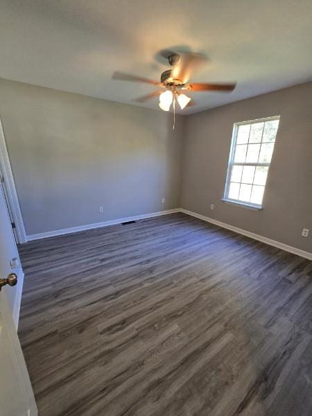 unfurnished room with ceiling fan and dark wood-type flooring