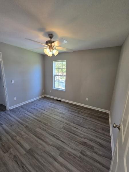 empty room with dark hardwood / wood-style flooring and ceiling fan