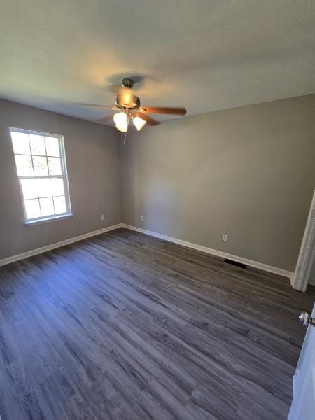 unfurnished room featuring ceiling fan and dark wood-type flooring