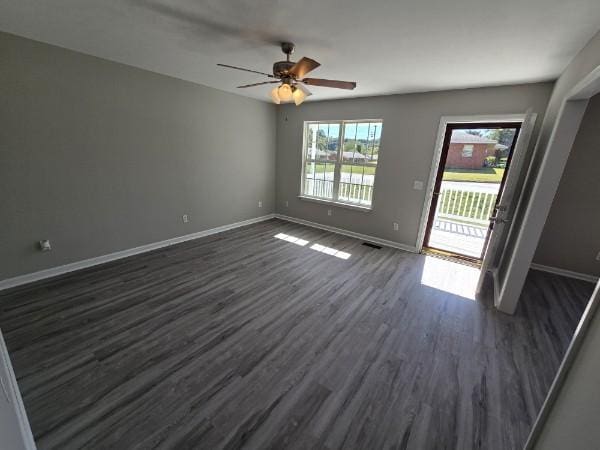 empty room with dark hardwood / wood-style floors and ceiling fan