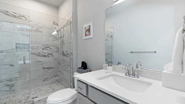 bathroom with vanity, a shower with shower door, and toilet