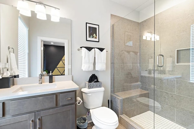 bathroom featuring vanity, toilet, and a shower with shower door