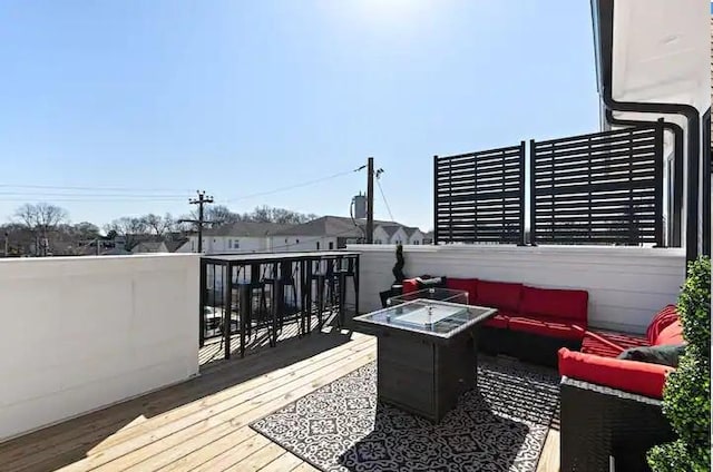 deck featuring an outdoor living space with a fire pit