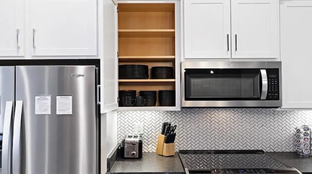 kitchen with decorative backsplash, white cabinetry, and appliances with stainless steel finishes