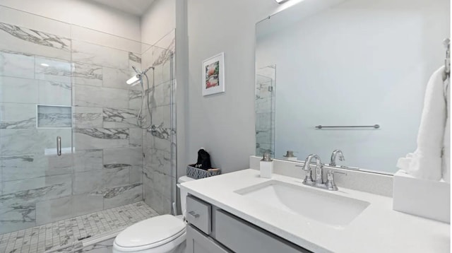 bathroom featuring an enclosed shower, vanity, and toilet