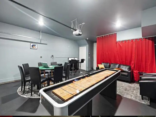 recreation room with finished concrete flooring and a garage