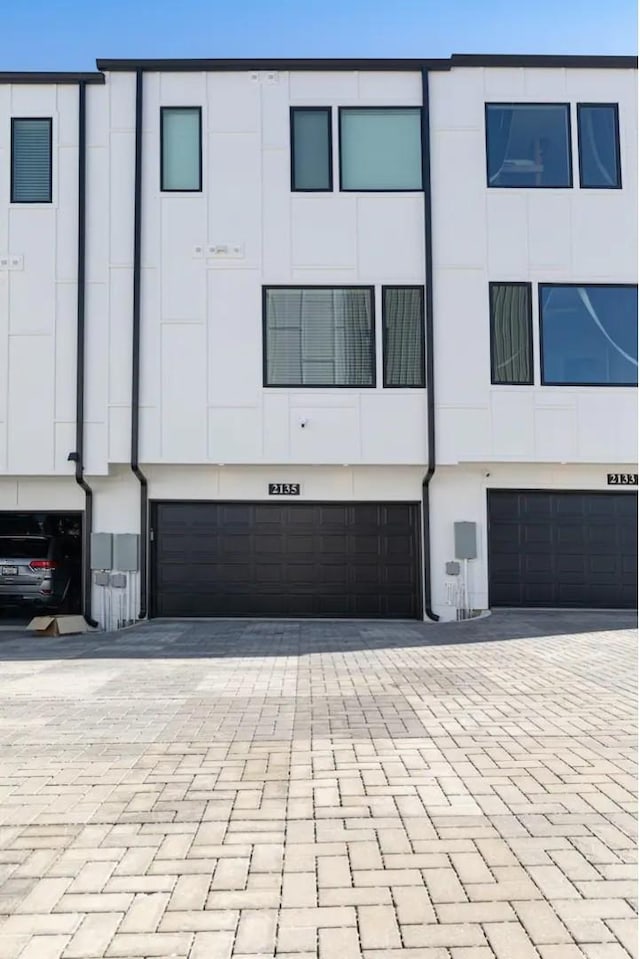 view of front of home with an attached garage and decorative driveway