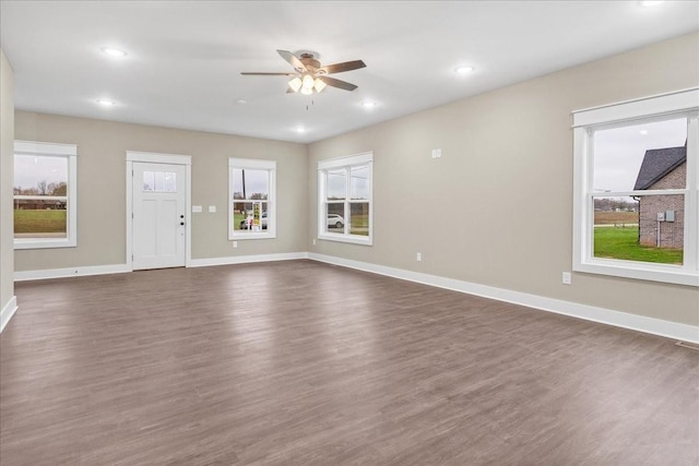 unfurnished living room with ceiling fan and dark wood-type flooring