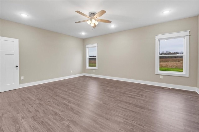 spare room with ceiling fan, dark hardwood / wood-style flooring, and plenty of natural light