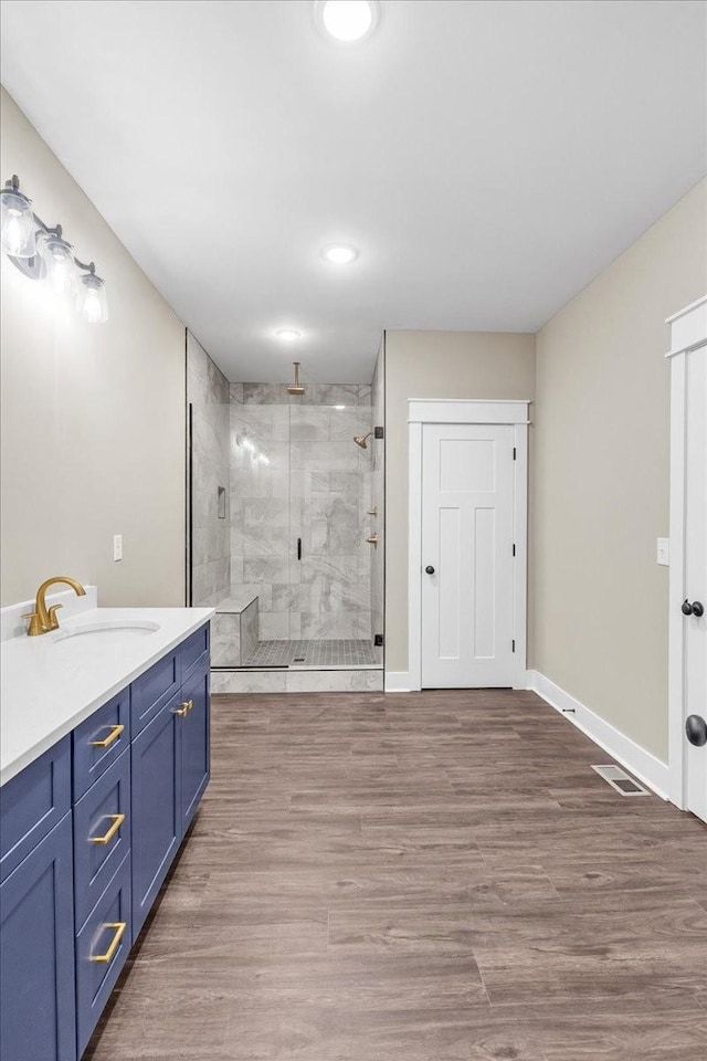 bathroom with vanity, an enclosed shower, and hardwood / wood-style flooring