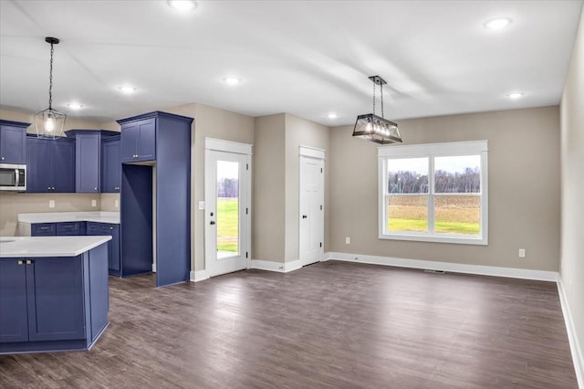 kitchen featuring dark wood-type flooring, pendant lighting, and blue cabinets