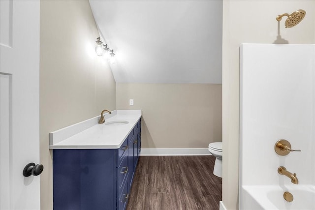 full bathroom with vanity, shower / washtub combination, hardwood / wood-style floors, toilet, and lofted ceiling