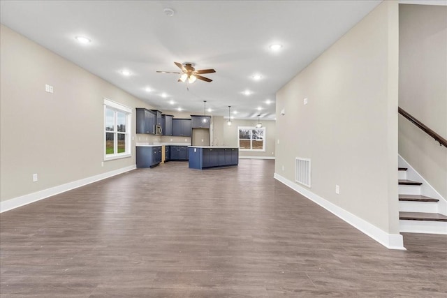 unfurnished living room with ceiling fan and dark wood-type flooring